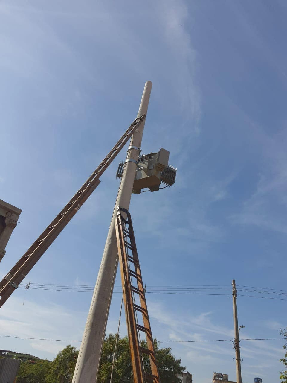 Instalação de transformador de subestação simplificada em poste de concreto com escadas de montagem