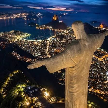 Vista noturna do Rio de Janeiro com o Cristo Redentor, a Baía de Guanabara e o Pão de Açúcar iluminados